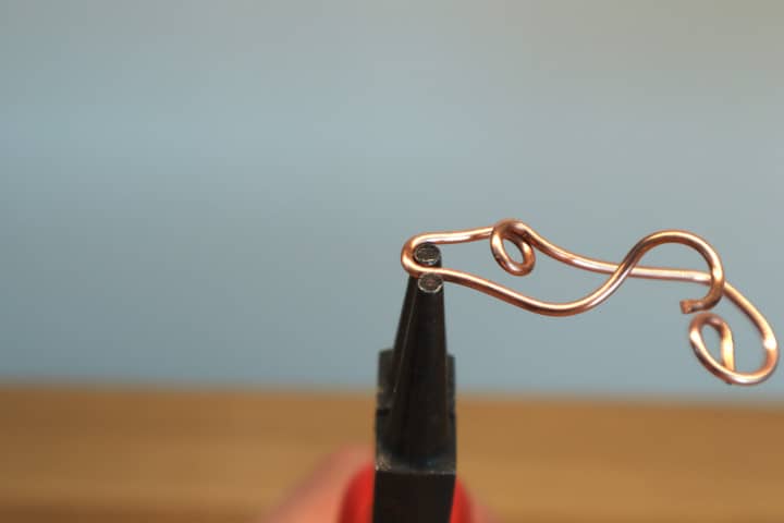 Thick copper wire bent with the tips of round nose pliers