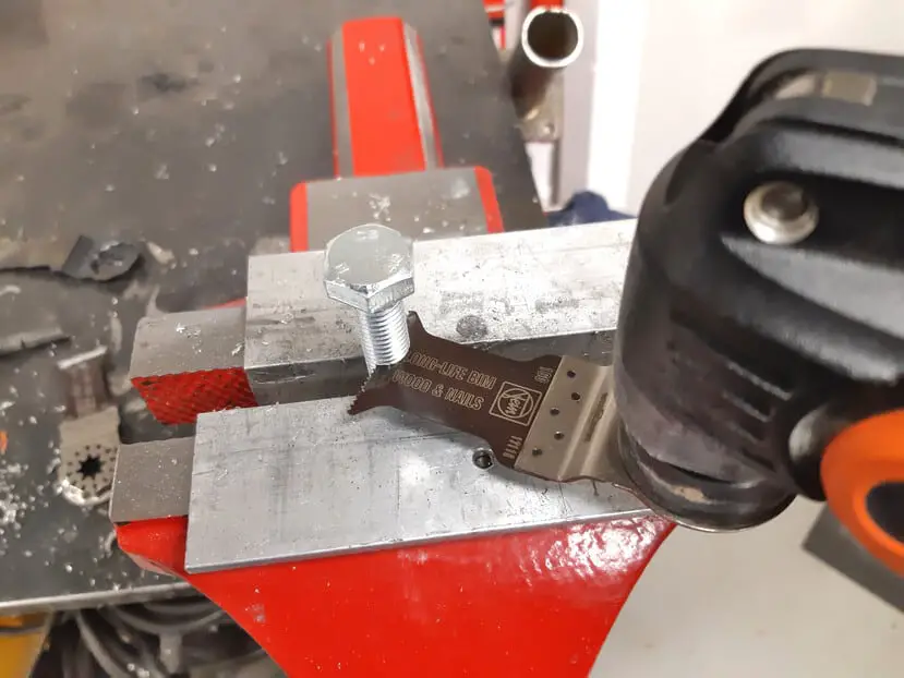 An oscillating multi-tool cutting a bolt