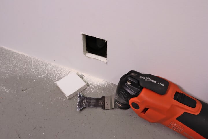 A hole cut into drywall with an oscillating multitool